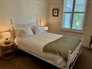 a bedroom with a white bed and a window at Hazeldene, charm & vines in Heathcote +13 photos