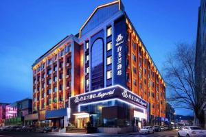 a building on a street with cars parked in front of it at Magnotel Hotel Dandong Railway Yalv River in Dandong