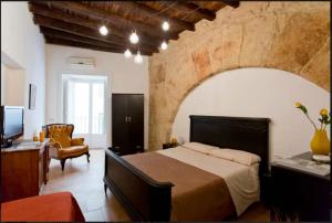 - une chambre avec un grand lit et une chaise dans l'établissement Casetta in centro, à Palerme