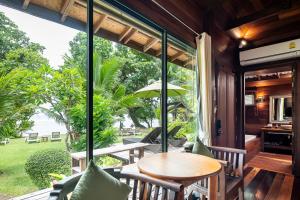a room with a table and chairs on a porch at GajaPuri Resort Koh Chang in Ko Chang