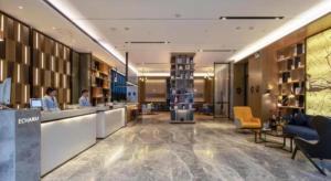 a hotel lobby with a reception desk and a woman at Echarm Hotel Nanning Chaoyang Square River View in Nanning