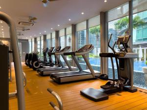 a row of treadmills in a gym with windows at KLCC View Penthouse in Kuala Lumpur