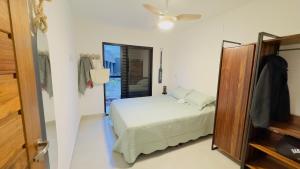 ein Schlafzimmer mit einem Bett und einem Spiegel in der Unterkunft Casaboa Paúba in São Sebastião + 13 Fotos