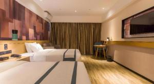 a hotel room with two beds and a flat screen tv at City Comfort Inn Nanning Kede Zoo Qingchuan Metro Station in Nanning