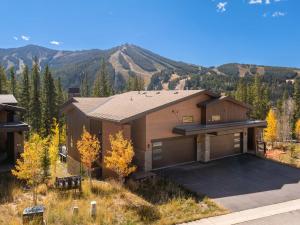Una casa con garaje con montañas al fondo. en Evergreen Reserve, en Winter Park
