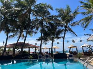una piscina en un resort con palmeras en Nico Beach Hotel, en Hikkaduwa