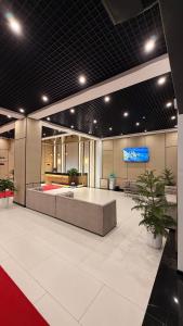 a lobby with a large room with a stage and plants at SUVON Hotel in Stantsiya Kyzyl-Tukumachi