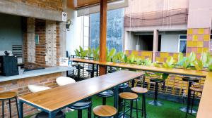 a row of tables and stools in a restaurant at Garden View by Calli Rooms in Jember