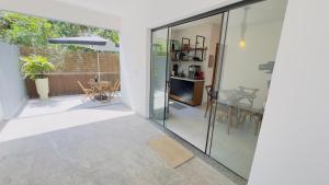 eine Glaserweiterung zu einem Haus mit einer Terrasse in der Unterkunft Casaboa Paúba in São Sebastião