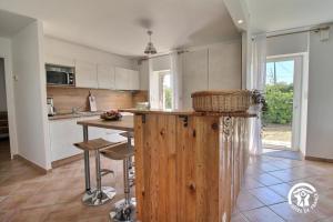 a kitchen with a wooden island in the middle at Les roses tremieres in Nivillac