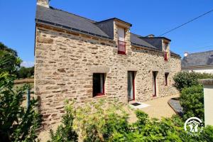 a large stone building with a black roof at Les roses tremieres in Nivillac