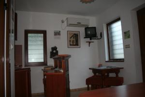 a living room with a table and two windows at Todorova House in Zlatograd