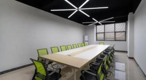 a conference room with a long table and green chairs at City Comfort Inn Dongguan Gaobu Avenue in Dongguan