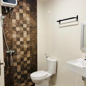 a bathroom with a toilet and a sink and a shower at Wisma teluk bayur sidapore Tb in Lamobuang