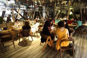a group of people sitting at tables in a restaurant at GreenTree Saigon Dong Du Hotel in Ho Chi Minh City