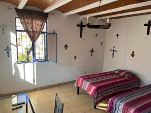 a bedroom with two beds and a window at Casa Angelitos in Guanajuato