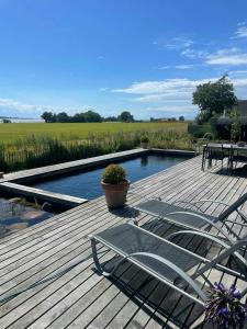 a deck with two chairs and a swimming pool at Holiday Home With Panoramic Views And Nature Pool in Harpelunde