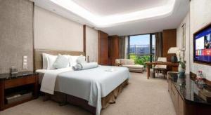 a hotel room with a large bed and a television at Days Hotel by Wyndham Hunan Changsha Convoy in Changsha