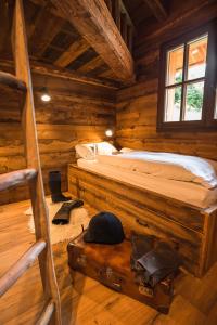um quarto com uma cama num chalé de madeira em Ledro Mountain Chalet em Ledro