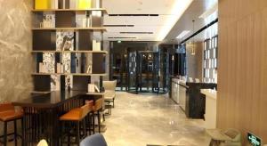 a restaurant with chairs and a bar in a building at Echarm Hotel Wuhan High-speed Rail Peace Park Metro Station in Wuhan