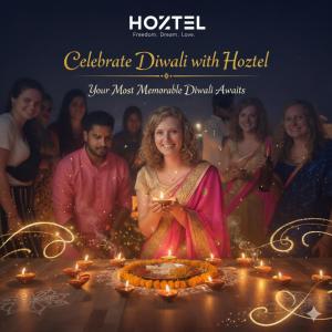 eine Gruppe von Menschen, die um einen Tisch mit Lichtern stehen in der Unterkunft Hoztel Jaipur in Jaipur
