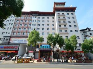 a large white building with a tower on top of it at City Comfort Inn Shiyan Wudang Mountain in Danjiangkou