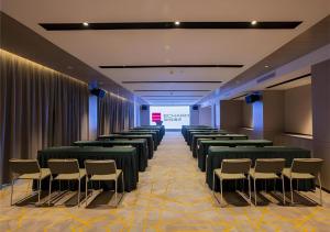 a room with rows of chairs and a screen at Echarm Hotel Nanning Dongge Macun Metro Station in Nanning