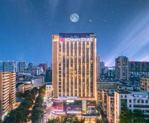 a tall building with a moon in the sky at Echarm Hotel Nanning Dongge Macun Metro Station in Nanning