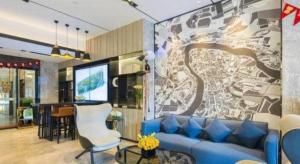a living room with a blue couch and a tv at Echarm Hotel Kunming High-speed Railway South Station Chunrong Street Metro Station in Kunming