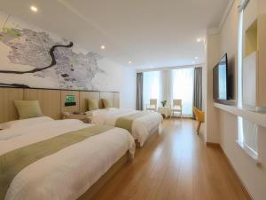 a hotel room with two beds and a map on the wall at Vatica Hotel Huangshan South Gate Terminal Station in Huangshan Scenic Area