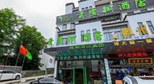 a building with a store in front of it at Vatica Hotel Huangshan South Gate Terminal Station in Huangshan Scenic Area