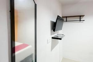 a room with a tv and a sliding glass door at RedDoorz at Batam Center 3 in Pulau Sembakau Kecil