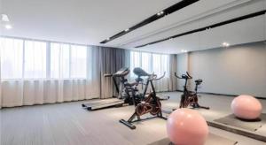 a gym with exercise bikes and balloons in a room at Echarm Hotel Changsha Xiangya Fushan in Changsha