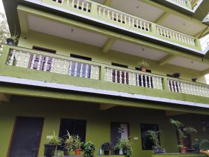 アランボールにあるSree Sai guest houseの鉢植えの植物が植えられたバルコニー付きの建物 +17枚の写真
