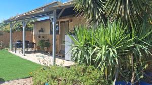 una casa con un pergolato accanto a un giardino di בקתת המפל a Eli Ad