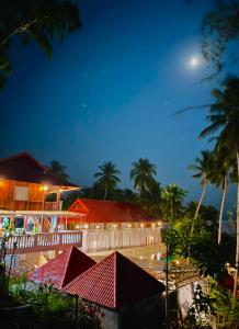 a hotel at night with the moon in the sky at Ecohouse Hòn Sơn in Lai Sơn