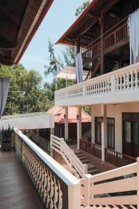 a building with a staircase and a balcony at Ecohouse Hòn Sơn in Lai Sơn