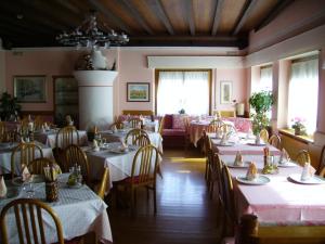 MelにあるAl Cavallino Rossoのテーブルと椅子が備わるレストラン