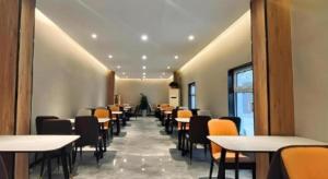 済南市にあるShell Hotel Shandong Jinan Daming Lakeの食堂のテーブルと椅子