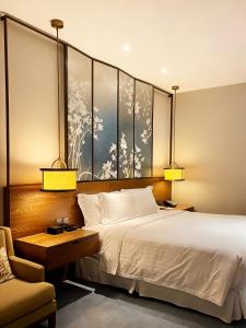 una habitación de hotel con una cama y una silla en HUALUXE Shanghai Twelve At Hengshan, en Shanghái