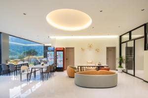 - un salon avec des tables, des chaises et un canapé dans l'établissement Yangshuo Soul Resort-Beside Yulong River, à Yangshuo