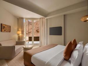 a bedroom with a bed and a couch and a television at Shaden Resort Al Ula, Managed by Accor in Al-ʿUla +208 photos