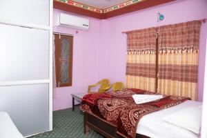 チトワンにあるHotel Sauraha Gaida Houseのベッドと窓のある小さな寝室 +151枚の写真