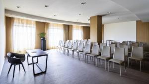 a conference room with white chairs and a table at BERDS Hotel Chisinau - MGallery Collection in Chişinău