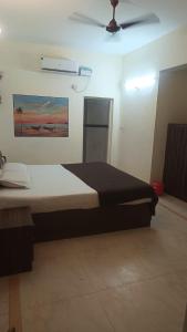 カナコナにあるCLUB Indiaのベッドと天井扇風機のある寝室