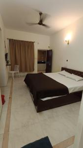 カナコナにあるCLUB Indiaの天井ファン付きの大きなベッドのある寝室