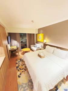 a hotel room with a large bed and a living room at The Hotel Residences at Acqua in Manila
