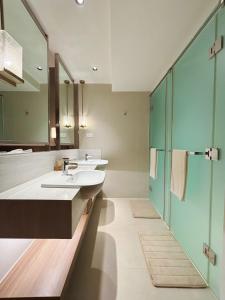 a bathroom with two sinks and a shower at The Hotel Residences at Acqua in Manila