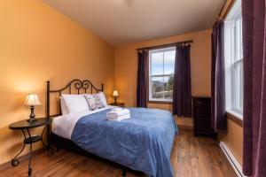 a bedroom with a bed and a large window at Condo 120B, Hot Tub, Panoramic Views & Game Area in Petite-Rivière-Saint-François +12 photos