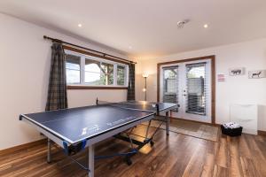 a ping pong table in a room with a window at Condo 120B, Hot Tub, Panoramic Views & Game Area in Petite-Rivière-Saint-François